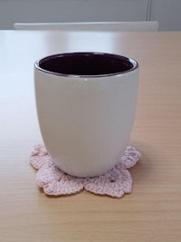 a white cup with a pink flower on top